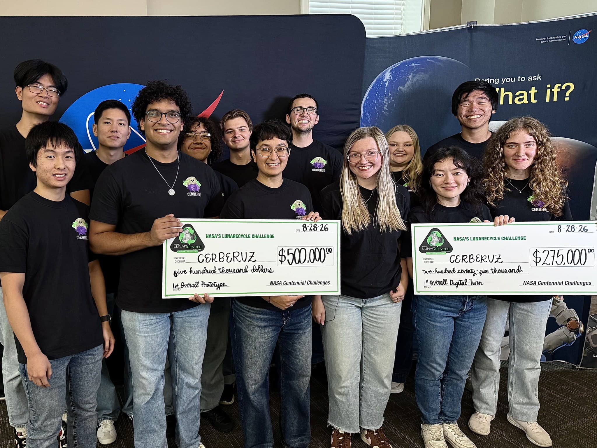 Members of MIT's CERBERUZ team hold oversized checks for $500,000 and $275,000 in front of NASA and Centennial Challenges backdrops after winning the LunaRecycle Challenge, Tuscaloosa, Ala., Aug. 28, 2026. Photo: NASA/Savannah Bullard. Source page: https://www.nasa.gov/directorates/stmd/prizes-challenges-crowdsourcing-program/centennial-challenges/nasa-awards-first-prize-in-phase-2-of-agencys-lunarecycle-challenge/